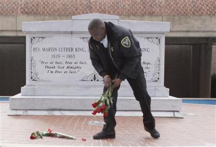 King Center security officer Kevin Baxter collects roses left at the crypt of Martin Luther King, Jr. in celebration of the King Holiday in Atlanta, Georgia, January 16, 2012.   REUTERS/Tami Chappell