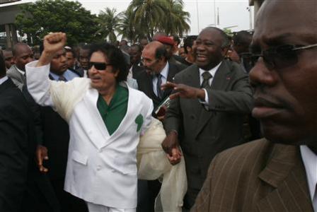 Libyan leader Muammar Gaddafi (L) is accompanied by Ivory Coast's President Laurent Gbagbo (R) during a welcoming ceremony upon his arrival at Felix Houphouet Boigny airport, outside Abidjan, at the start of a two-day visit to Ivory Coast June 27, 2007. REUTERS/Thierry Gouegnon/Files