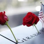 A pair of roses and a U.S. flag are left on one of the panels containing the names of the victims of the attacks on the first day that the 9/11 Memorial was opened to the public at the World Trade Center site in New York, September 12, 2011. REUTERS/Mike Segar