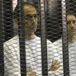 Gamal (L) and Alaa Mubarak, sons of former Egyptian President Hosni Mubarak, stand inside a cage at a courtroom in Cairo June 2, 2012. REUTERS/Stringer