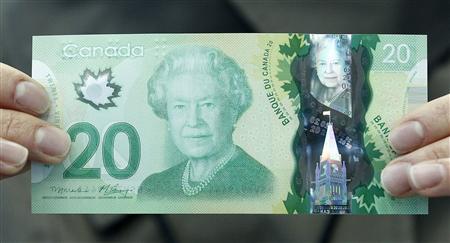 The new Canadian 20 dollar bill made of polymer is displayed at the Bank of Canada in Ottawa in this May 2, 2012, file photo. Canada is known for the sugar maple, emblazoned on its red-and-white flag, but the Bank of Canada has put what one careful botanist says is a foreign Norway maple leaf on its new currency. The untrained eye might not at first spot the difference between the maple leaf on the new $20, $50 and $100 bills and the sugar maple that is endemic to North America. REUTERS/Chris Wattie/Files