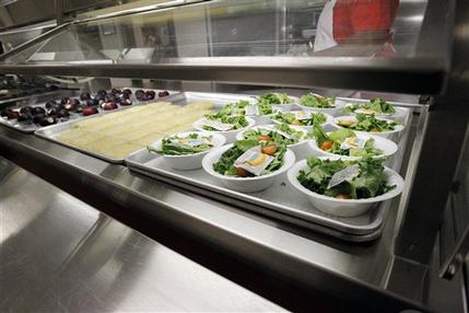 FILE - In this Sept. 12, 2012 file photo, side salads, apple sauce and plums  await the students of Eastside Elementary School in Clinton, Miss. The government for the first time is proposing broad new standards to make school snacks healthier, a move that would ban the sale of almost all candy, high-calorie sports drinks and greasy foods on campus.  (AP Photo/Rogelio V. Solis, File)