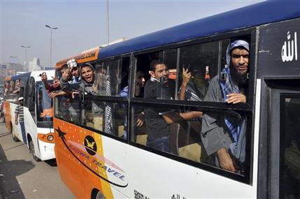 FILE - In this Saturday, Dec. 1, 2012 file photo, supporters of Egyptian President Mohammed Morsi arrive by bus to a rally in front of Cairo University in Cairo, Egypt. For most of the 85 years since its inception, the Muslim Brotherhood operated secretively as an outlawed group, working underground and often repressed by governments. But even after its political success since Hosni Mubarak's ouster, the group is still suspected of carrying on secretive operations. (AP Photo/Samuel Mohsen, El Shourouk Newspaper, File) EGYPT OUT