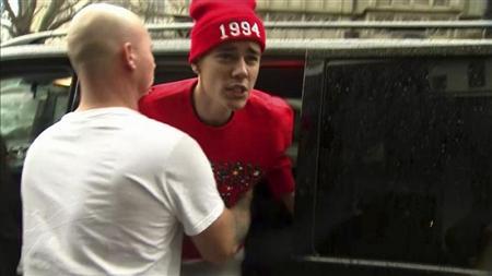 Canadian pop star Justin Bieber is held back by a member of his security team as he confronts a photographer outside his hotel in central London in this still image taken from video on March 8, 2013. REUTERS/Reuters TV