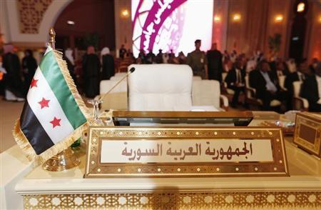 The Syrian opposition flag is seen in front of the seat of the Syrian delegation at the opening the Arab League summit in Doha March 26, 2013. REUTERS/Ahmed Jadallah