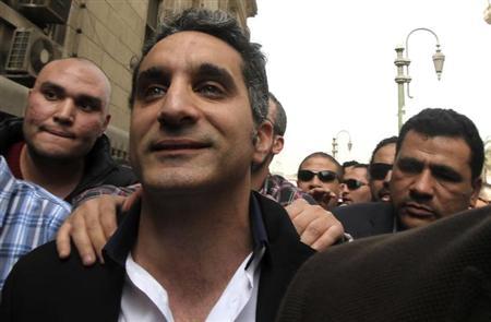 Bassem Youssef (C), the country's best-known satirist, gestures to journalists and activists as he arrives at the high court to appear at the prosecutor's office in Cairo March 31, 2013. REUTERS/Mohamed Abd El Ghany