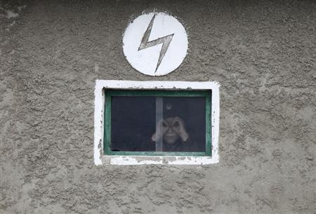 A North Korean soldier looks out of the window of a guard tower, on the banks of Yalu River, about 100 km (62 miles) from the North Korean town of Sinuiju, opposite the Chinese border city of Dandong, April 16, 2013. REUTERS/Jacky Chen (NORTH KOREA - Tags: SOCIETY POLITICS MILITARY) - RTXYNS1