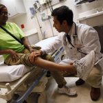 Patient Sharon Dawson Coates has her knee examined by Dr. Narang at University of Chicago Medicine Urgent Care Clinic in Chicago, June 28, 2012. REUTERS/Jim Young