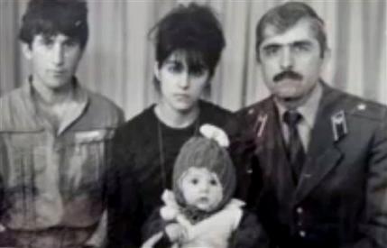 In this image taken from a video, an undated family photo provided by Patimat Suleimanova, the aunt of USA Boston bomb suspects, shows Anzor Tsarnaev left, Zubeidat Tsarnaev holding Tamerlan Tsarnaev and Anzor's brother Mukhammad Tsarnaev. Now known as the angry and grieving mother of the Boston Marathon bombing suspects, Zubeidat Tsarnaev is drawing increased attention after federal officials say Russian authorities intercepted her phone calls, including one in which she vaguely discussed jihad with her elder son. In another, she was recorded talking to someone in southern Russia who is under FBI investigation in an unrelated case, U.S. officials said. (AP Photo/Patimat Suleimanova)