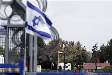 An Israeli flag (L) flutters near a Syrian flag at the Kuneitra border crossing between Israel and Syria, on the Golan Heights in this March 5, 2013 file photo. REUTERS/Baz Ratner/Files