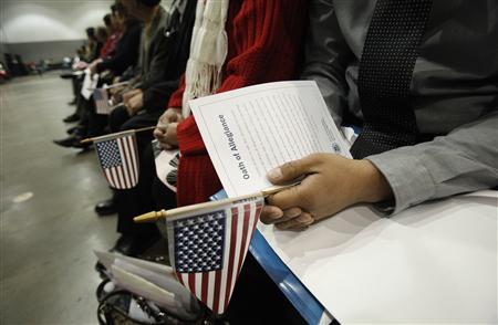 Candidates hold U.S. flags during a naturalization ceremony to become new U.S. Citizens at Convention Center in Los Angeles, California February 27, 2013. REUTERS/Mario Anzuoni