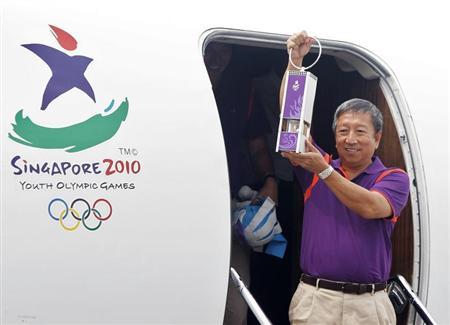 Chairman of the Singapore Youth Olympic Committee Ng Ser Miang arrives with a safety lantern containing the Youth Olympic flame at Changi Airport in Singapore August 5, 2010. REUTERS/Vivek Prakash