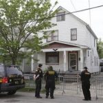 Sheriff deputies stand outside a house in Cleveland Tuesday, May 7, 2013, the day after three women who vanished a decade ago were found there. Amanda Berry, Gina DeJesus and Michelle Knight, who went missing separately about a decade ago, were found in the home just south of downtown Cleveland and likely had been tied up during years of captivity, said police, who arrested three brothers. (AP Photo/Tony Dejak)