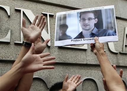 A supporter holds a picture of Edward Snowden, a former CIA employee who leaked top-secret information about U.S. surveillance programs, outside the U.S. Consulate General in Hong Kong Thursday, June 13, 2013. The news of Snowden's whereabouts, revealed by an editor of a local newspaper that interviewed him Wednesday, is the first since he went to ground Monday after checking out of his hotel in this autonomous Chinese territory. (AP Photo/Kin Cheung)