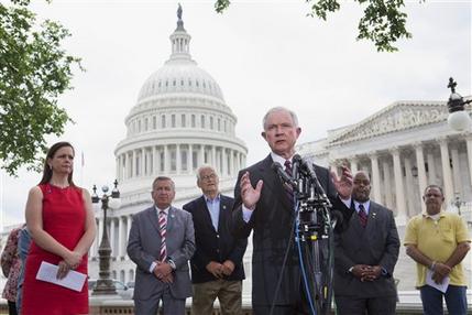 Jenny Beth Martin, co-founder of the Tea Party Patriots, listens at left, as Sen. Jeff Sessions, R-Ala., speaks at a news conference hosted by the Tea Party Patriots to oppose the Senate immigration reform bill, Thursday, June 20, 2013, on Capitol Hill in Washington. From left are, Martin; Akady Faktorovich, an immigrant from the former Soviet Union; Hans Marsen, an immigrant from England; Sessions; Niger Innis with TheTeaParty.Net, and George Wilkerson with The Remembrance Project. White House-backed immigration legislation gained momentum in the Senate on Thursday as lawmakers closed in on a bipartisan compromise to spend tens of billions of dollars stiffening border security without delaying legalization for millions living in the country unlawfully. (AP Photo/Jacquelyn Martin)