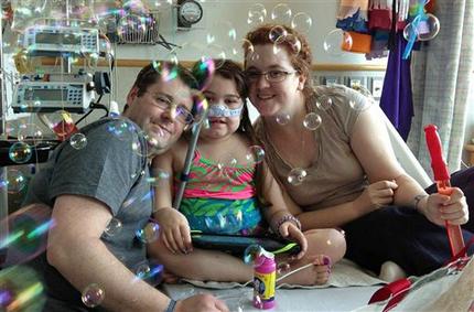 FILE - In this May 30, 2013 file photo provided by the Murnaghan family, Sarah Murnaghan, center, celebrates the 100th day of her stay in Children's Hospital of Philadelphia with her father, Fran, left, and mother, Janet. A federal judge in Philadelphia on Wednesday, June 5, 2013 made the dying 10-year-old eligible to seek donor lungs from an adult transplant list. (AP Photo/Murnaghan Family, File)