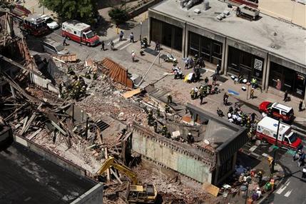 Rescue personnel work the scene of a building collapse in downtown Philadelphia, Wednesday, June 5, 2013.  A four-story building being demolished collapsed Wednesday on the edge of downtown, injuring 12 people and trapping two others, the fire commissioner said. Rescue crews were trying to extricate the two people who were trapped, and the dozen people who were injured were taken to hospitals with minor injuries, according to city Fire Commissioner Lloyd Ayers. (AP Photo/Jacqueline Larma)