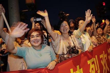 Supporters of Chinese President Xi Jinping cheer as they watch the motorcade carrying President Xi arrive in Indian Wells, Calif., Thursday, June 6, 2013. President Barack Obama and Chinese President Xi Jinping, seeking a fresh start to a complex relationship, are retreating to a sprawling desert estate for two days of talks on high-stakes issues, including cybersecurity and North Korea's nuclear threats. (AP Photo/Jae C. Hong)