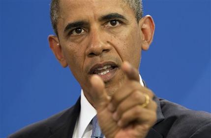 FILE - In this June 19, 2013 file photo, U.S. President Barack Obama gestures during a news conference with German Chancellor Angela Merkel at the German Chancellery in Berlin. In the shifting narrative of the Obama administration, Edward Snowden, the man whose leaks of top-secret material about government surveillance programs have tied the national security apparatus in knots and brought charges under the Espionage Act, has now been demoted to a common fugitive unworthy of international intrigue or extraordinary pursuit by the U.S. government. (AP Photo/Evan Vucci, File)