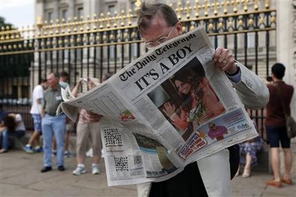 A man reads a newspaper carrying front page news of the birth of a baby boy of Prince William and Kate, Duchess of Cambridge, outside Buckingham Palace in London, Tuesday, July 23, 2013. (AP Photo/Sang Tan)