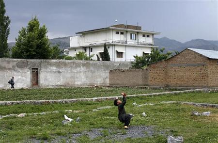 A boy plays with a tennis ball in front of Osama bin Laden's compound in Abbottabad in this May 5, 2011 file picture. REUTERS/Akhtar Soomro/Files