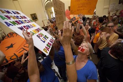 Opponents and supporters of abortion rights rally in the State Capitol rotunda in Austin, Texas on Friday, July 12, 2013. The Texas Senate convened Friday afternoon to debate and ultimately vote on some of the nation's toughest abortion restrictions, its actions being watched by fervent demonstrators on either side of the issue. (AP Photo/Tamir Kalifa)