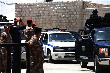 Radical Muslim preacher Abu Qatada, sits in the back seat of a police vehicle, as he leaves to Jordanian military court, in Amman, Jordan, Sunday, July 7, 2013. A Jordanian military prosecutor says he has charged a radical Muslim preacher with conspiring to carry out al-Qaida-linked attacks on Americans, Israelis and other Westerners in this key U.S. ally. Abu Qatada, 53, arrived in Jordan earlier Sunday after being deported from Britain. (AP Photo/Mohammad Hannon)