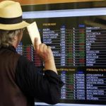 A man looks at an electronic board displaying stock index outside a bank in downtown Milan