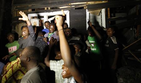 Residents chant slogans as they demonstrate outside the ruins of a house struck by a mortar bomb during an operation in Goma