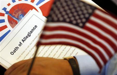 The Oath of Allegiance is held next to an American flag during a Special Naturalization Ceremony at the U.S. Treasury Department in Washington