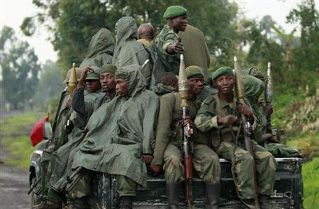 Congolese armed forces (FARDC) soldiers ride on their pick-up truck as they advance to a new position while battling M23 rebels in Kibati near Goma