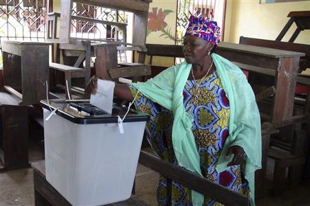 A woman casts her ballot at a polling station in Guinea's capital Conakry