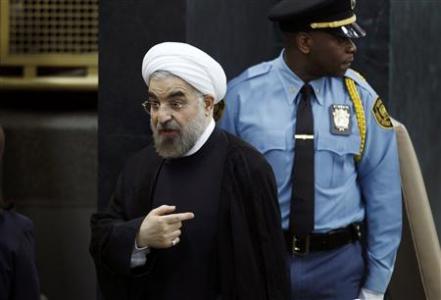 Iran's President Hassan Rouhani talks to a United Nations official as he departs after concluding his address to the 68th United Nations General Assembly at U.N. headquarters in New York