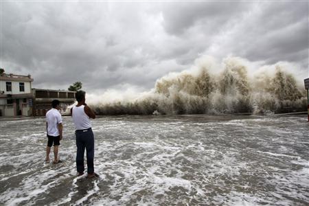 People watch waves hit the shores as Typhoon Usagi approaches in Shantou