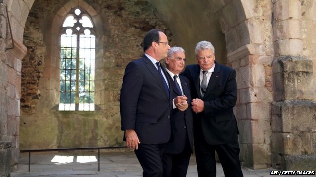 President Gauck and President Hollande hold hands with survivor Robert Hebras