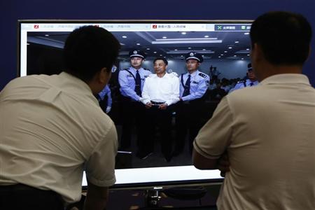 Men look at a screen displaying a picture of disgraced Chinese politician Bo Xilai standing trial on the website of a court's microblog, in Jinan, Shandong province September 22, 2013. REUTERS/Aly Song