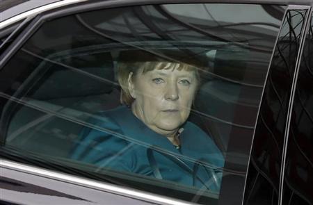 German Chancellor Merkel sits in her limousine as she leaves first round of coalition talks in Berlin