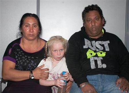 A Roma couple and a girl found living with them in central Greece, are seen in a handout photo distributed by the Greek police