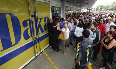 Shoppers crowd outside a Daka store as they wait to shop for electronic goods in Caracas