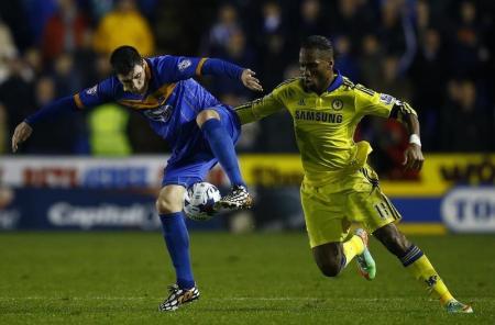 Shrewsbury Town's Grant challenges Chelsea's Drogba during their League Cup fourth round soccer match in Shrewsbury