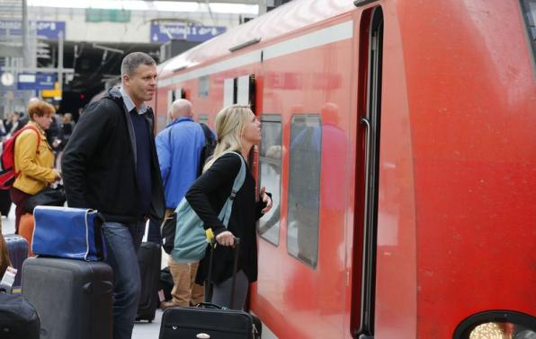 Passengers ask for information from a train driver of German railways, Deutsche Bahn (DB) at the railways station of the Cologne-Bonn airport