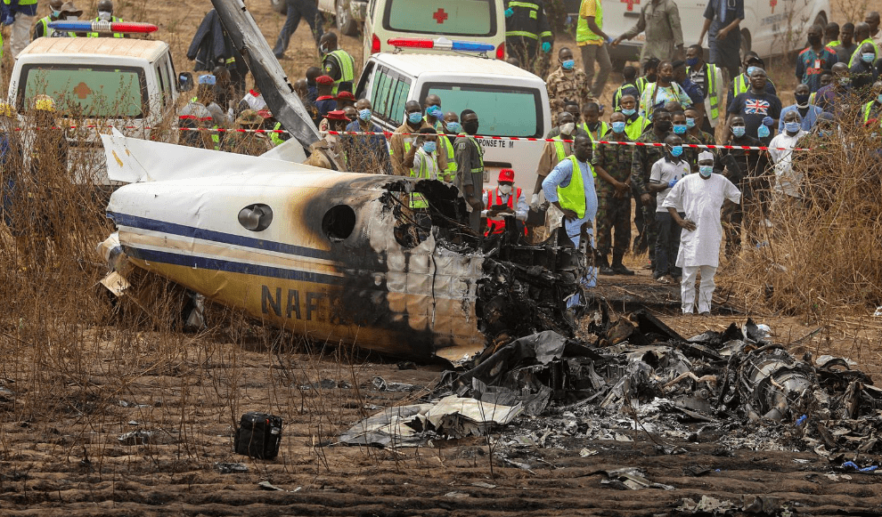 Rescuers and people gather near the debris of a Nigerian air force plane