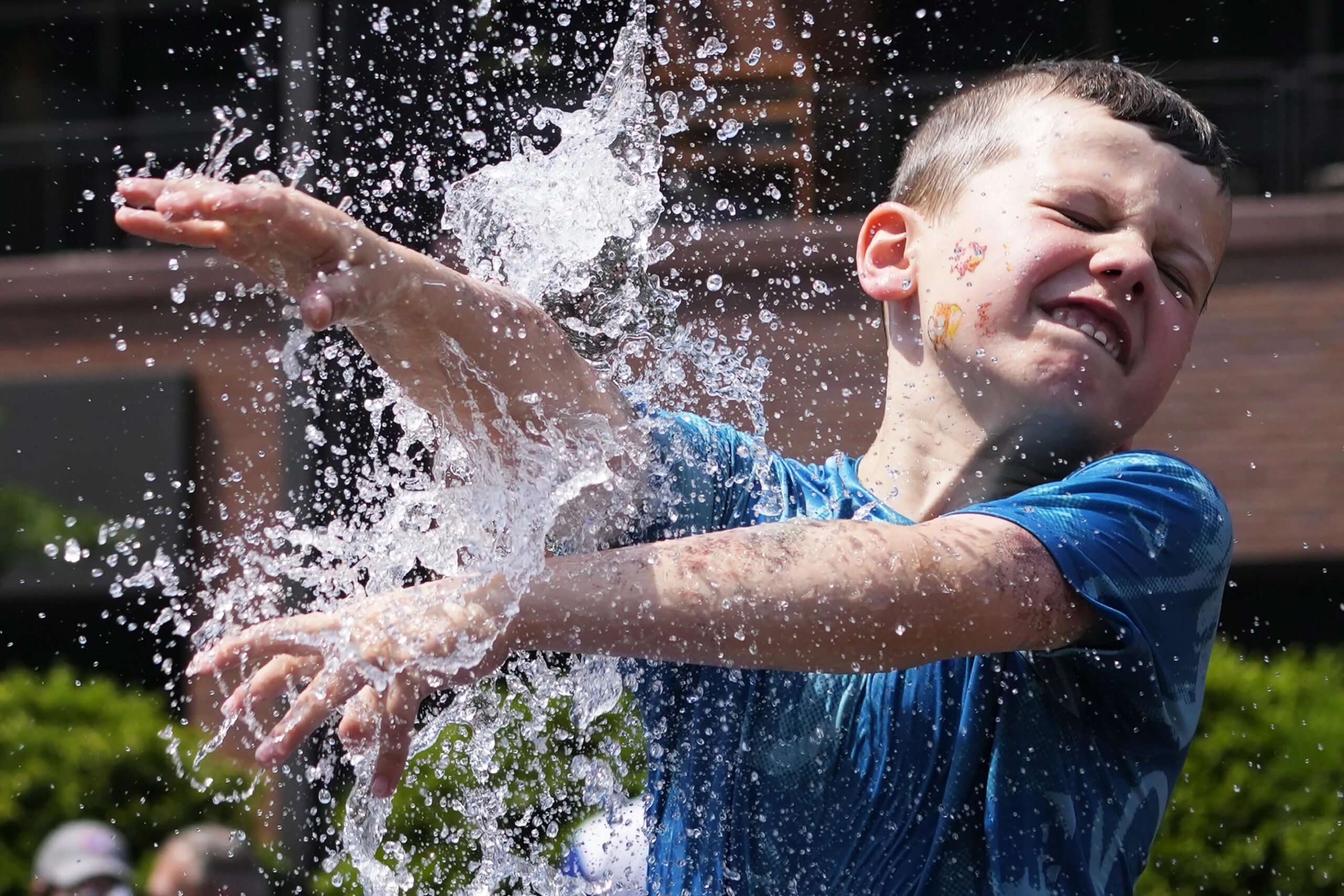 A boy cools off at a fountain