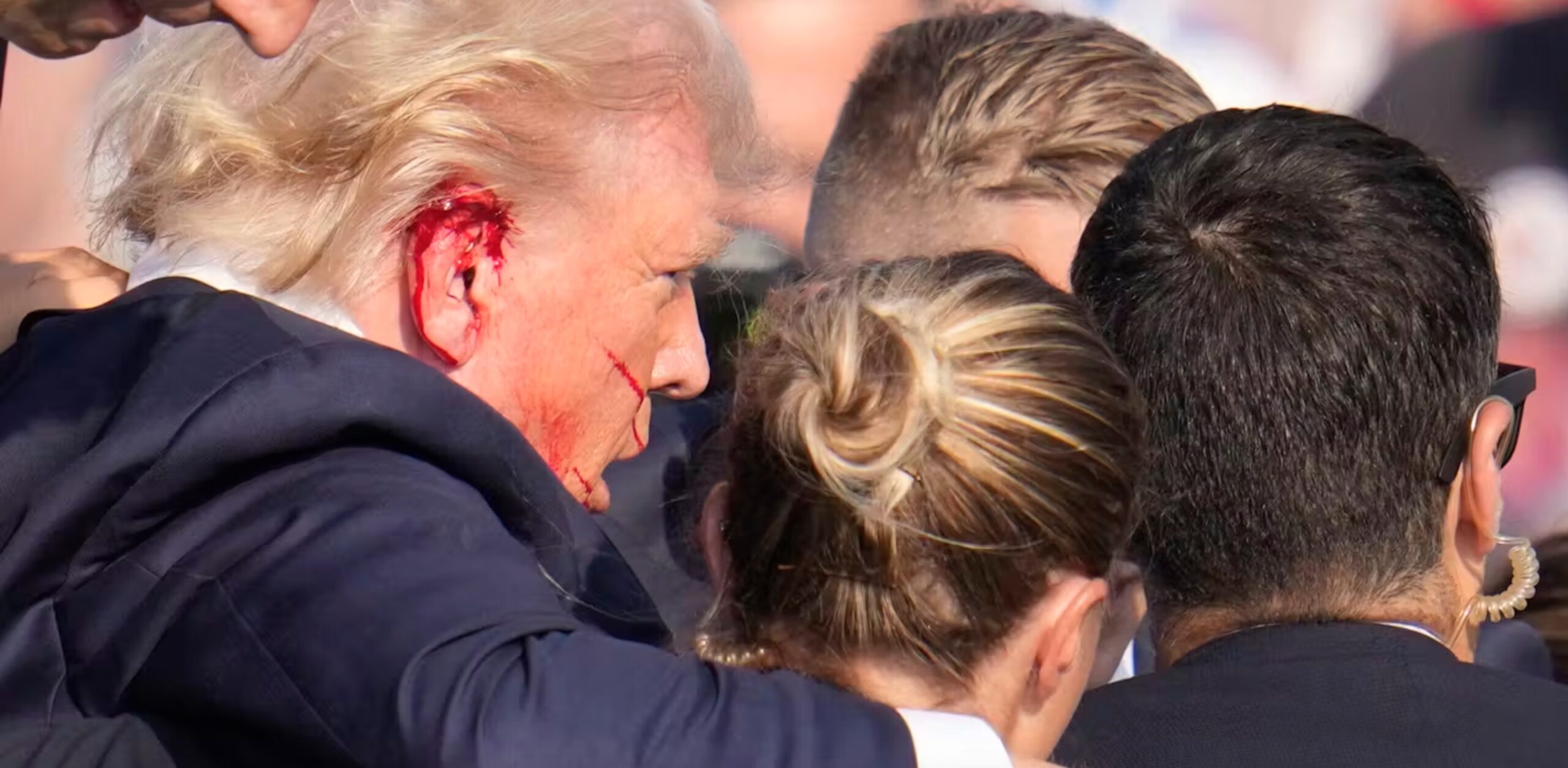 Republican presidential candidate and former President Donald Trump is surrounded by U.S. Secret Service agents as he is helped off the stage at a campaign rally in Butler, Pa., on Saturday.