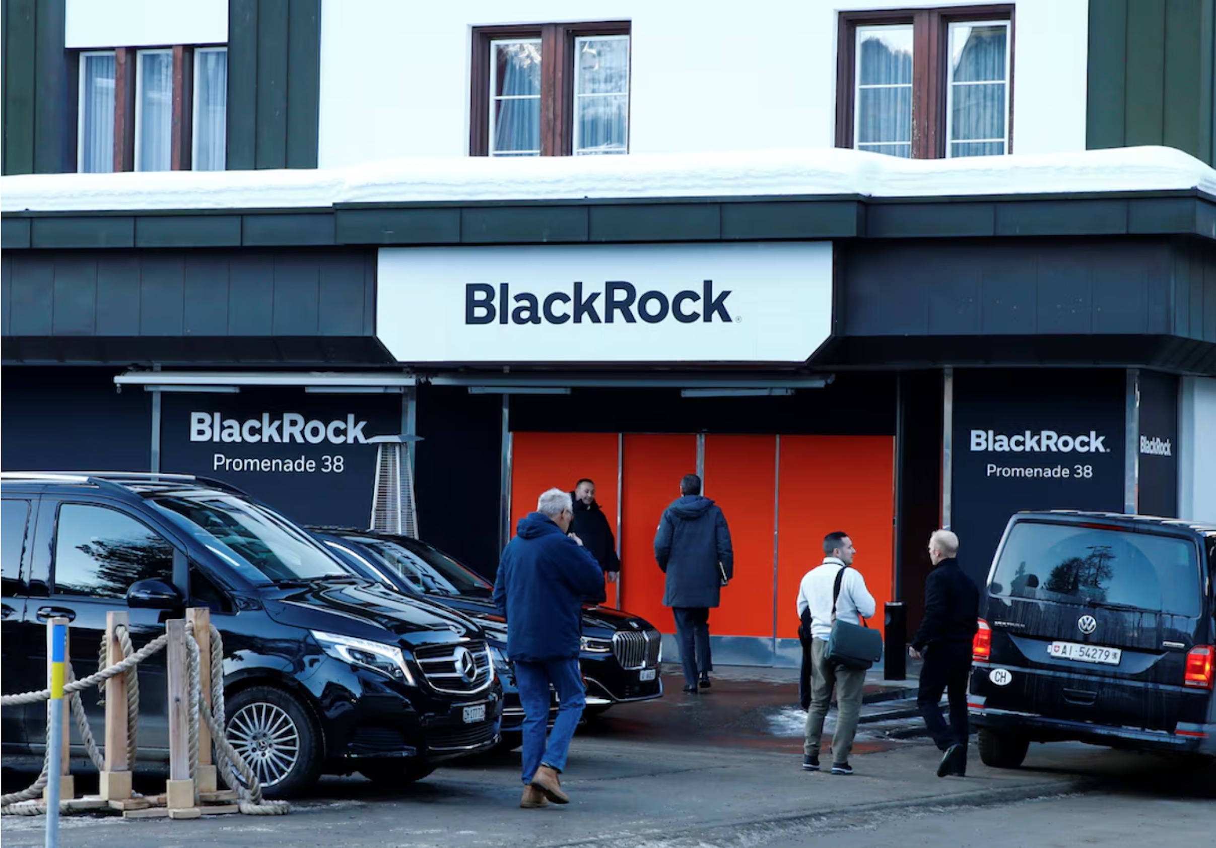 People are seen in front of a showroom that hosts BlackRock in Davos