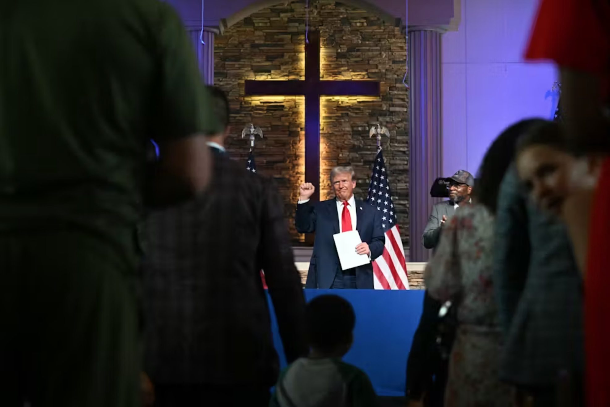 Donald Trump raises his fist after participating in a community roundtable at the 180 Church in Detroit on June 15, 2024.