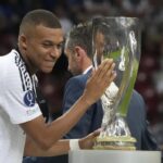 Real Madrid’s Kylian Mbappe touches the trophy during the medal ceremony for the UEFA Super Cup Final soccer match between Real Madrid and Atalanta at the Narodowy stadium in Warsaw, Poland, Wednesday, Aug. 14, 2024.