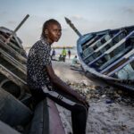 Salamba Ndiaye, a 28-year-old who tried to migrate to Europe twice, poses for a photo at the beach in Thiaroye-Sur-Mer, Senegal