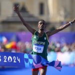 Ethiopia’s Tamirat Tola celebrates after crossing the finish line to win the gold medal at the end of the men’s marathon competition at the 2024 Summer Olympics, Saturday, Aug. 10, 2024, in Paris, France.