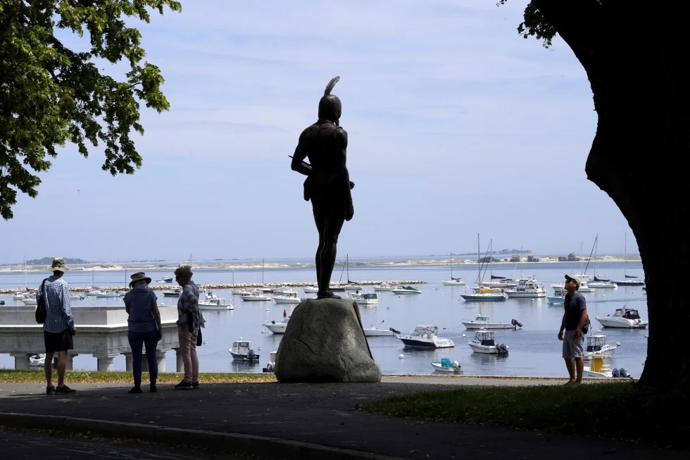 Visitors stand near a 1921 statue of the Wampanoag leader Massasoit, center, Wednesday, June 9, 2021